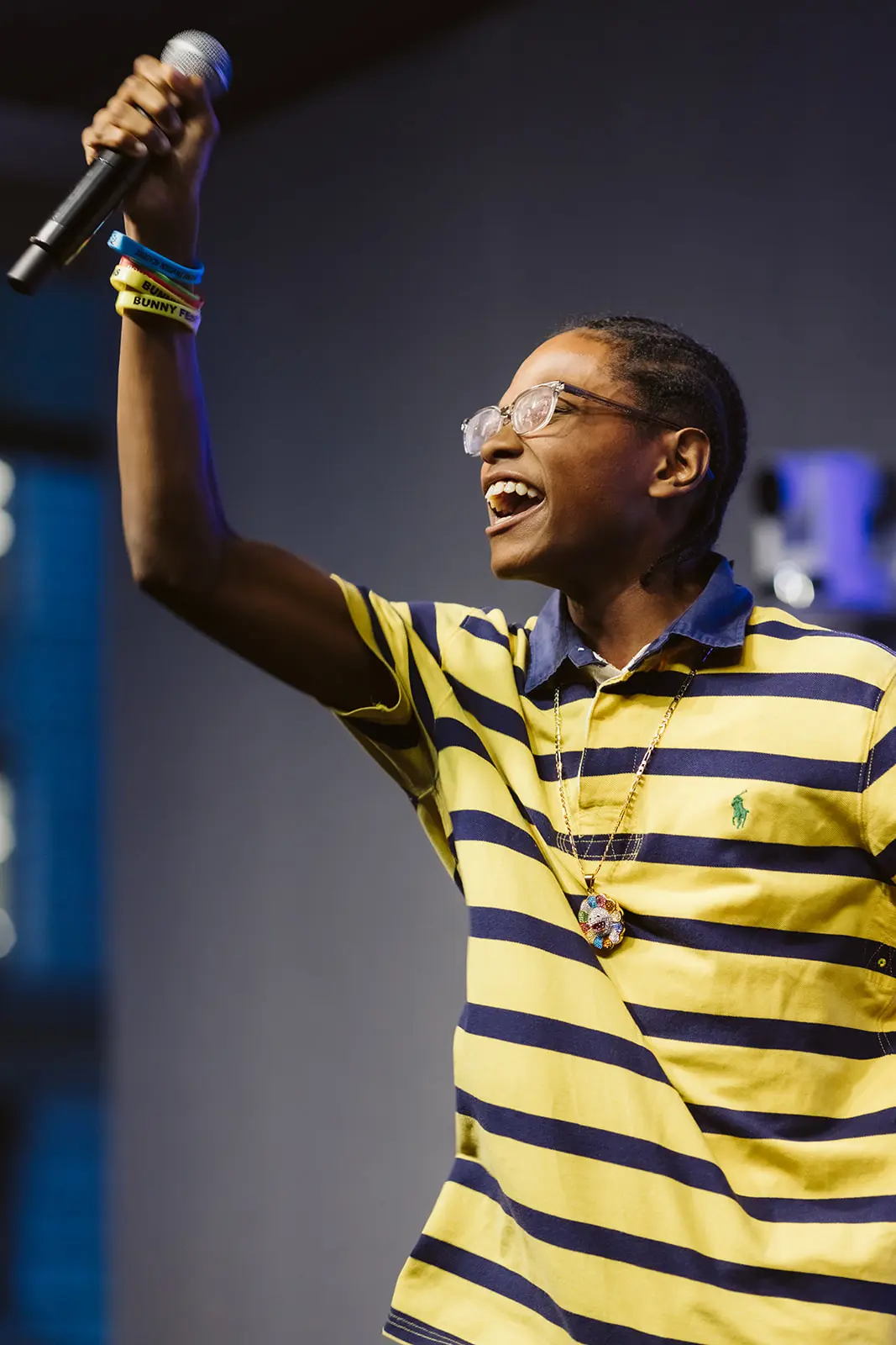 Young man holding a microphone in the air with a hyge smile on his face.