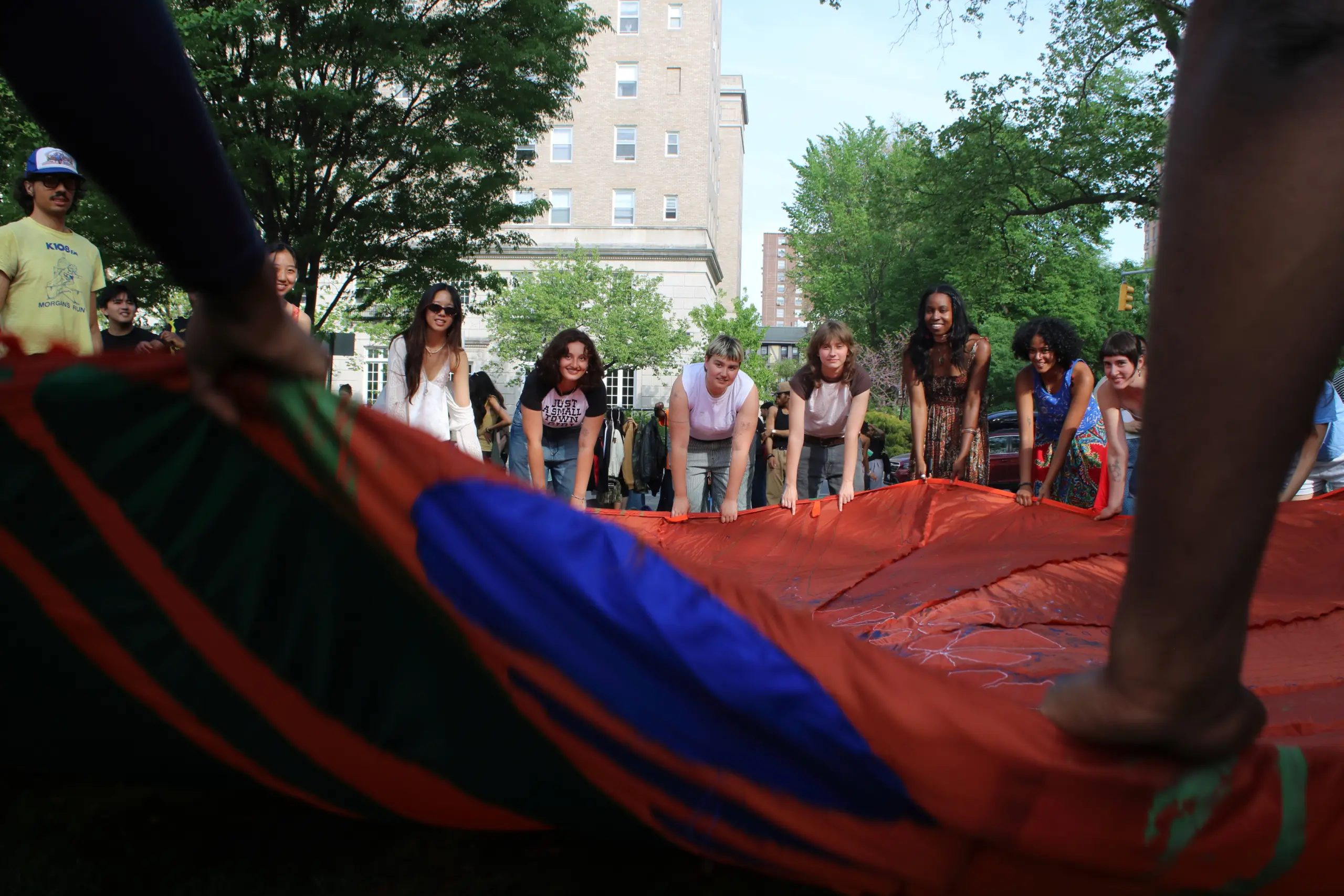 People in a park about to lift up a large circular fabric
