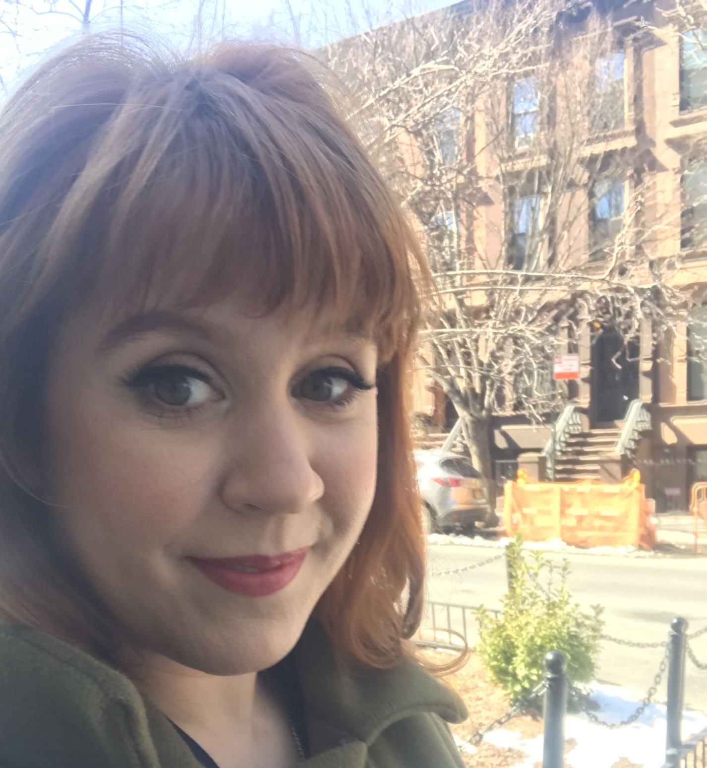 Close up of woman smiling from the stoop of a brownstone