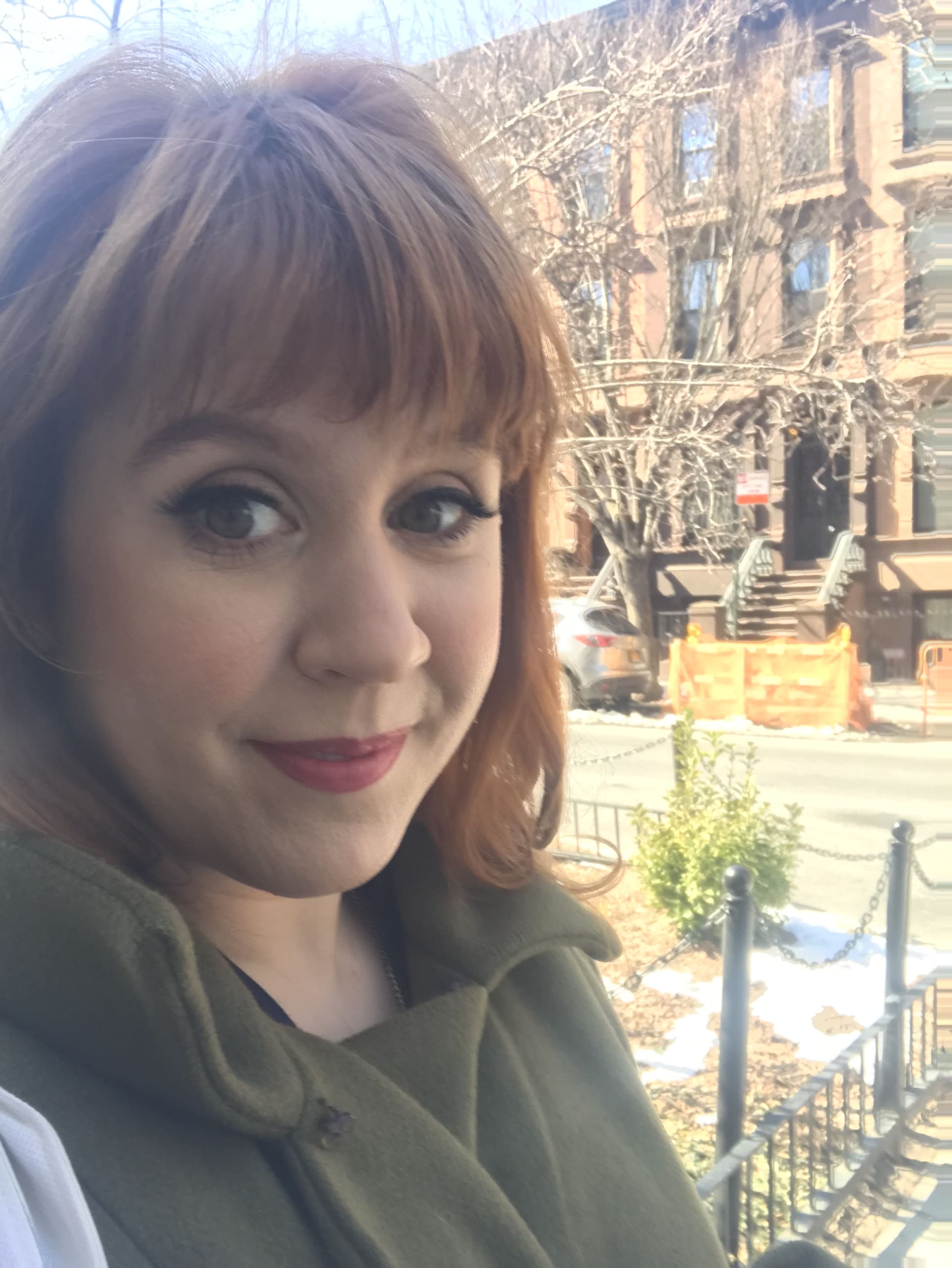 Close up of woman smiling from the stoop of a brownstone