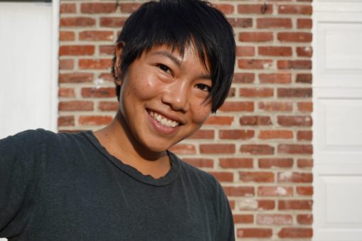 Portrait of a woman smiling with red brick background