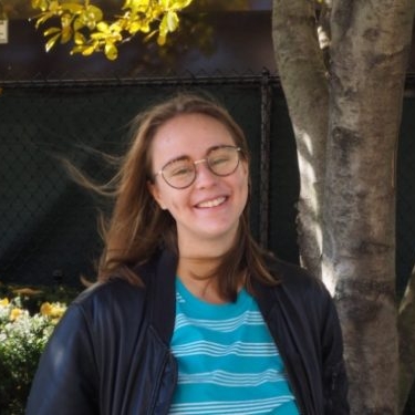 Woman with glasses in front of a tree