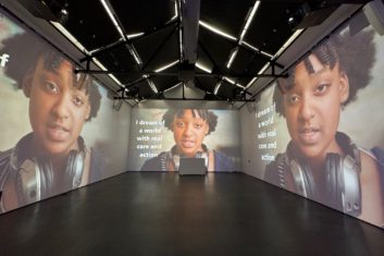 Gallery room with projection of a spoken word performance by high school student