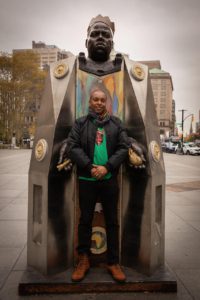 Artist Sherwin Banfield in front of his public sculptures of Notorious B.I.G.