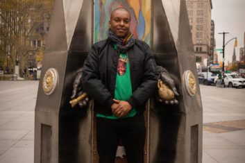 Artist Sherwin Banfield in front of his public sculptures of Notorious B.I.G.