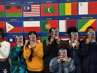 Students holding up their new books