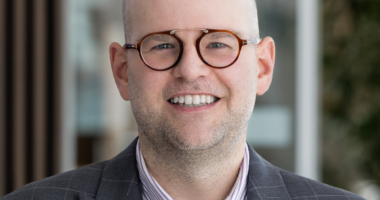 Man in glasses smiling at camera