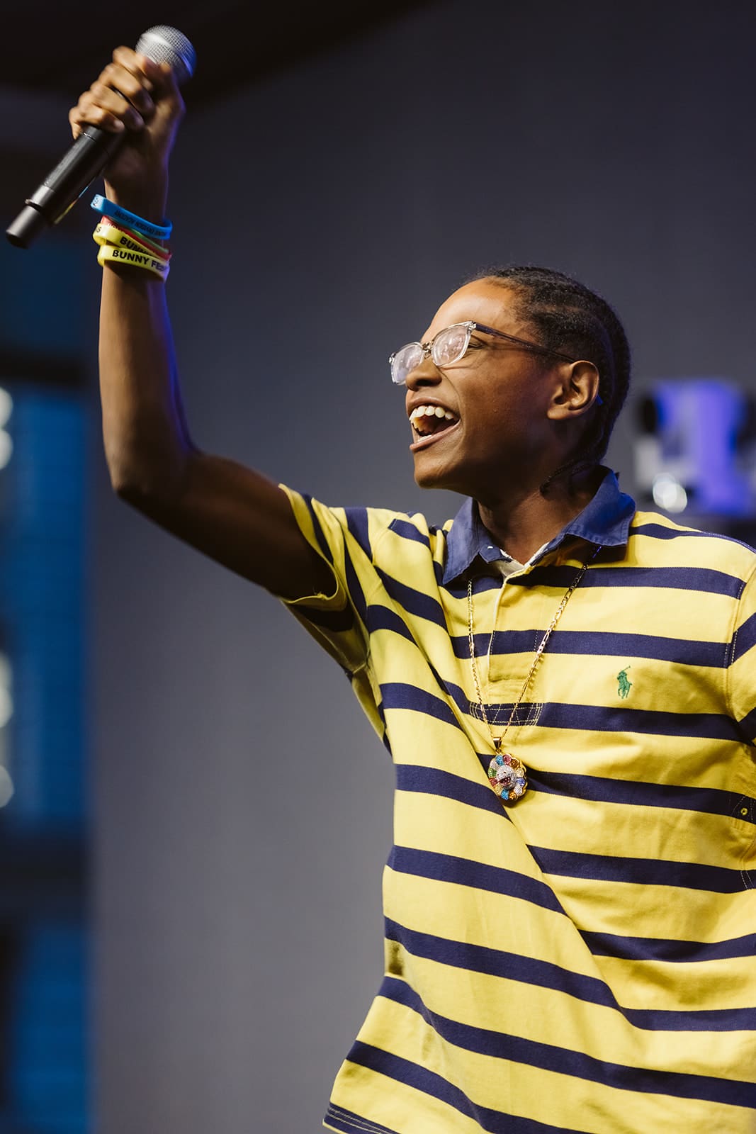 Young man holding a microphone in the air with a hyge smile on his face.