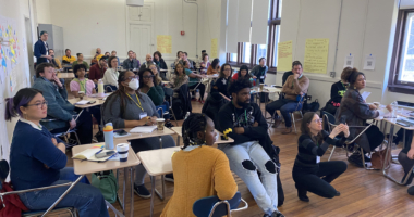 Large group of people in a conference room attending a facilitated session.