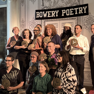 Group of NYS Teaching Artists on stage at Bowery Poetry Club accepting their tokens of esteem by City Lore's People's Hall of Fame.