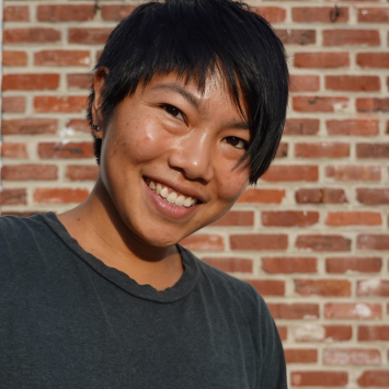 Portrait of a woman smiling with red brick background