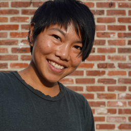 Portrait of asian woman smiling with red brick background