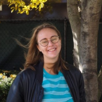Woman with glasses in front of a tree